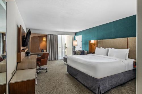 a hotel room with a large bed and a desk at Holiday Inn Oxnard - Ventura by IHG in Oxnard