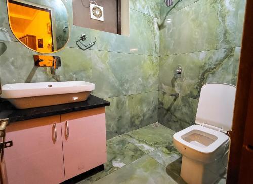 a bathroom with a sink and a toilet and a mirror at Nook 1BR close to Mall Road and Naini Lake in Nainital