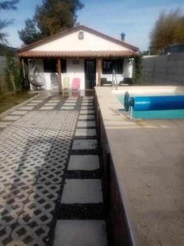 a house with a swimming pool and a building at Casa con piscina climatizada para 6 personas en Parque del plata in Parque del Plata
