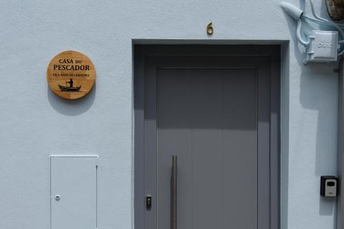 a sign on the side of a building with a door at Casa do Pescador - Vila Nova de Cerveira in Vila Nova de Cerveira