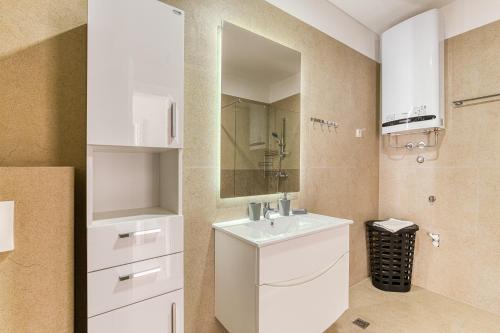 a bathroom with a white sink and a mirror at Vertmont Villa in Sveti Stefan