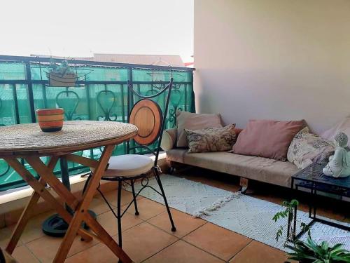 una sala de estar con un sofá y una mesa en K a Z - L'Ara Bleu, en Saint-Denis