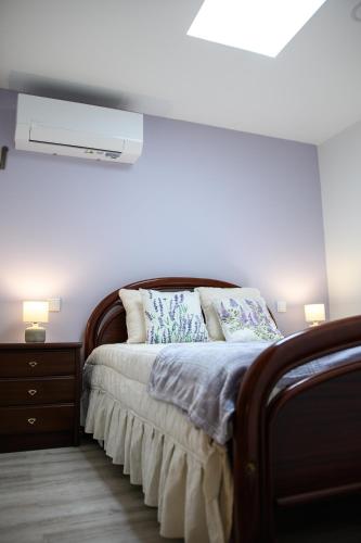 a bedroom with a bed with a white wall at Casa do Pescador - Vila Nova de Cerveira in Vila Nova de Cerveira