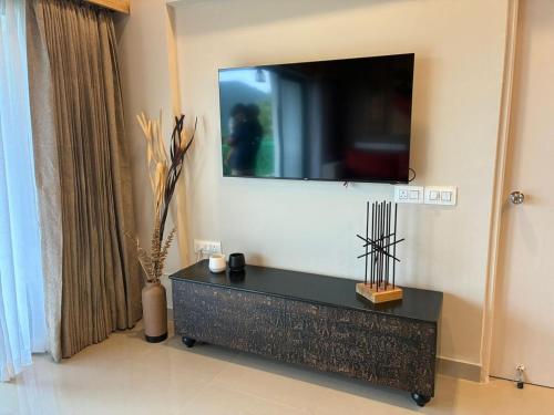 a living room with a tv on the wall at The Tribe - by Kudrat's Nilaya with pool in Canacona