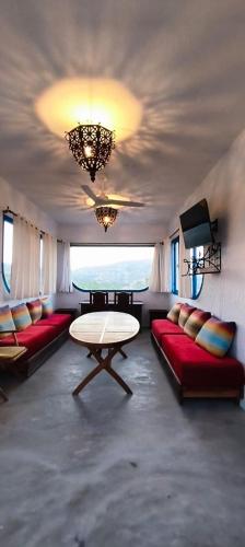 a living room with red couches and a table at La Casa de las Higueras Dar Karmus Tetouan in Tetouan