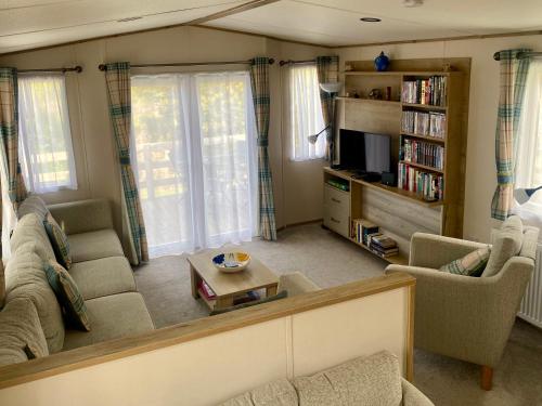 a living room with a couch and a table at Bynack Lodge in Boat of Garten