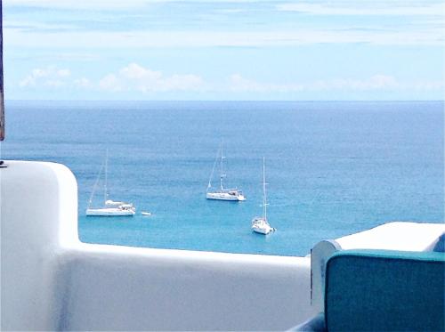 a view of boats in the ocean from a balcony at Merchia Bay Villas Mykonos in Merchia Beach
