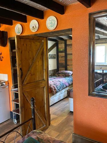 a room with an open door with a bed and a mirror at Yarm Cottages The Byre Sleeping 4 Next to Fox Covert Pub in Kirk Leavington