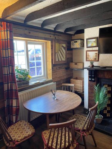 a dining room with a table and chairs and a window at Yarm Cottages The Byre Sleeping 4 Next to Fox Covert Pub in Kirk Leavington