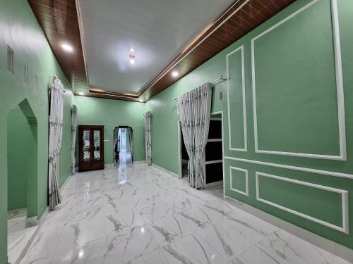 a hallway with green walls and a marble floor at NH Villa Lombok in Sangyang