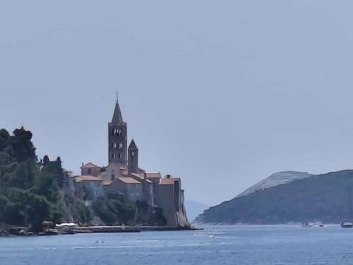 a church on an island in the water at Apartment Rab in Palit