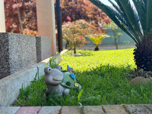 a toy frog sitting in the grass next to a wall at Guest House Sant'Antonio 
