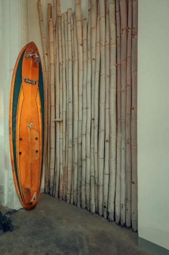 a wooden surfboard sitting next to a bamboo curtain at Why Not Hostel in Mirissa