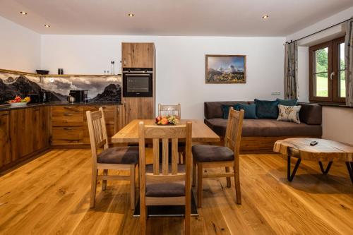 a kitchen and living room with a table and a couch at Lacklehen in Ramsau
