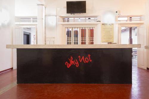 a black counter with red writing on it in a room at Why Not Hostel in Mirissa