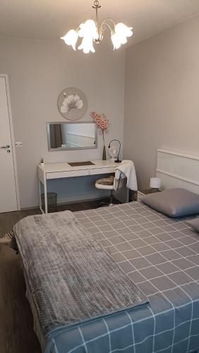 Un dormitorio con una cama y un escritorio. en Apartament Säärijarventie 22, en Kuopio