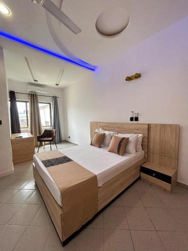 a bedroom with a large bed with a blue ceiling at Bekouvi Smart Suite - City & Sea in Cotonou