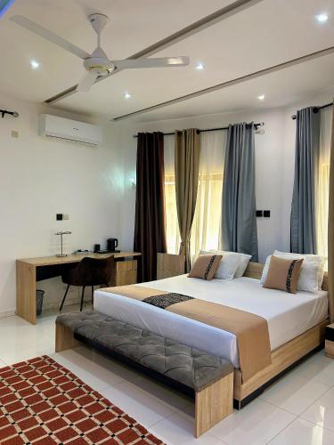 a bedroom with a large bed and a desk at Bekouvi Smart Suite - City & Sea in Cotonou