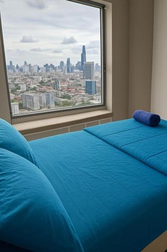 a bedroom with two blue beds and a large window at Skyline View 1 Bedroom Near RCA, Thonglor And Nana in Bangkok