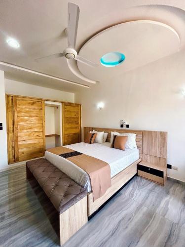 a bedroom with a large bed with a ceiling at Bekouvi Smart Suite - City & Sea in Cotonou