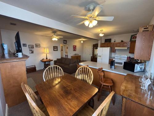 a kitchen and living room with a wooden table and chairs at Hermann Crown Suites in Hermann