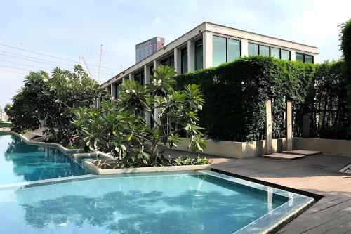 a swimming pool in front of a building at Skyline View 1 Bedroom Near RCA, Thonglor And Nana in Bangkok