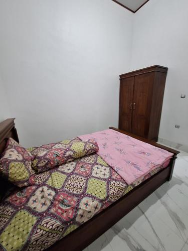 a bedroom with a bed with a quilt on it at NH Villa Lombok in Sangyang