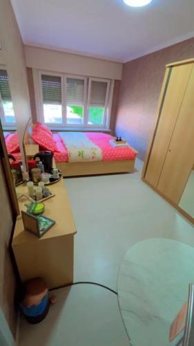 a bedroom with a bed and a table and a mirror at Gloryapartement in Roeselare