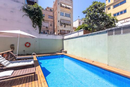 a swimming pool on top of a building with an umbrella at Apartment Barcelona Rentals - Gracia Pool Apartments Center in Barcelona