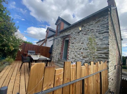 a wooden deck with a wooden fence and a table at Comme une Douce Parenthèse in Châteaubriant