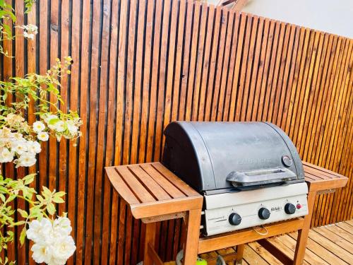a grill sitting on a bench next to a fence at Comme une Douce Parenthèse in Châteaubriant