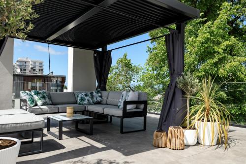 a black pergola with a couch and chairs on a patio at Aqua Bluemica ADULTS ONLY in Międzyzdroje
