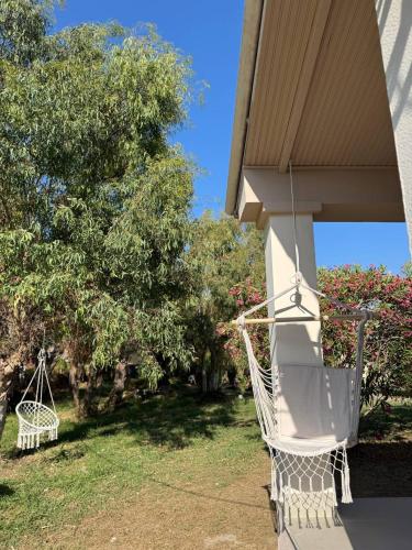 a porch with a hammock on the side of a house at Villa Sunlight Sidari in Sidari