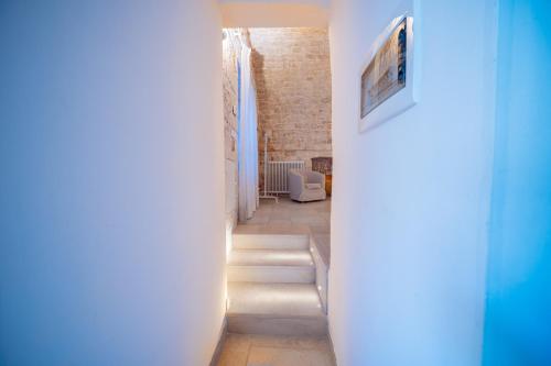 a hallway with white walls and a blue wall at Dimora Imma in Conversano