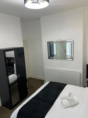 a bedroom with a large bed and a mirror at Favourite Ensuite Room in Middlesbrough