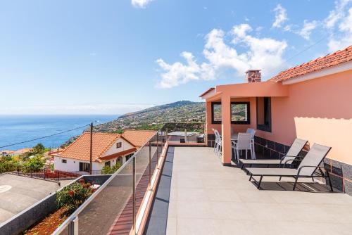 ein Haus mit Balkon mit Blick auf das Meer in der Unterkunft Casa Por Do Sol ll in Arco da Calheta
