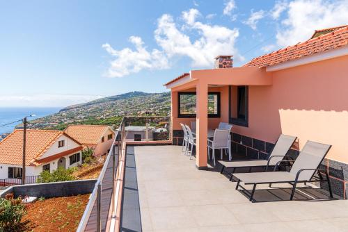 Ein Balkon mit Stühlen und Blick aufs Meer in der Unterkunft Casa Por Do Sol ll in Arco da Calheta