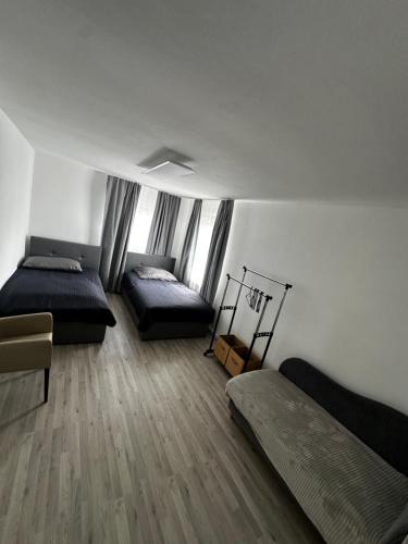 a bedroom with two beds and a wooden floor at Zimmervermietung Wels in Wels