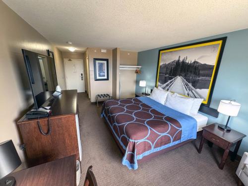 a hotel room with a bed and a desk at Super 8 by Wyndham Edmonton South in Edmonton
