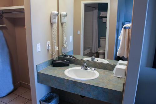 a bathroom with a sink and a mirror and a phone at Super 8 by Wyndham Edmonton South in Edmonton