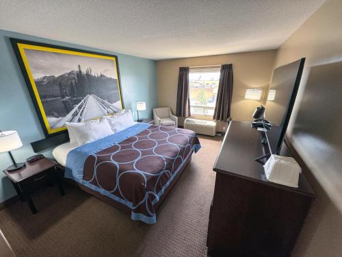 a hotel room with a bed and a desk at Super 8 by Wyndham Edmonton South in Edmonton