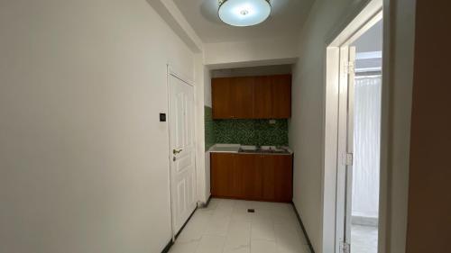 a small kitchen with a sink and a door at Abaት Guest House in Addis Ababa