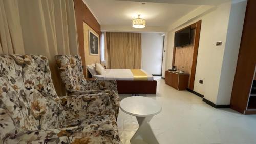 a hotel room with a bed and a couch and a table at Abaት Guest House in Addis Ababa