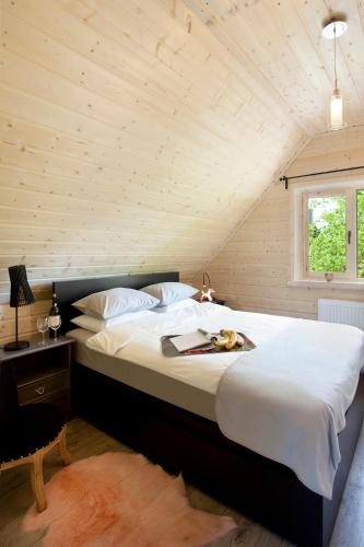 a bedroom with a large bed in a attic at SeaUSasino - Luksusowe Drewniane Domy z Kominkami in Sasino