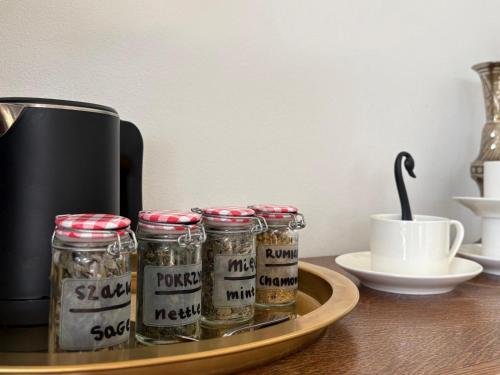 a tray with four jars of spices on a table at Apartament Jezioro Łabędzie in Białla