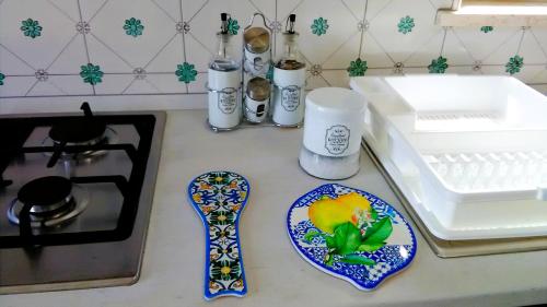 a kitchen counter with a stove and a plate and a sink at Casa delle Campane in Scala