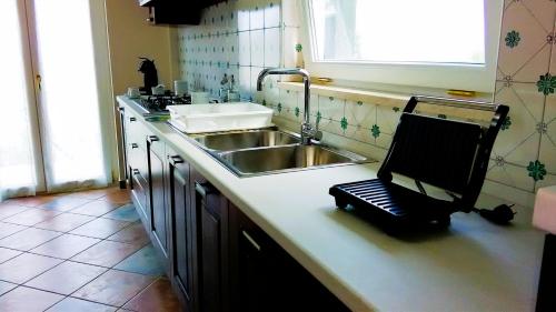 a kitchen with a sink and a counter with a slicer at Casa delle Campane in Scala