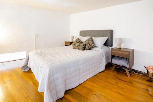 a bedroom with a white bed and a wooden floor at Casa Praxedis in Santiago