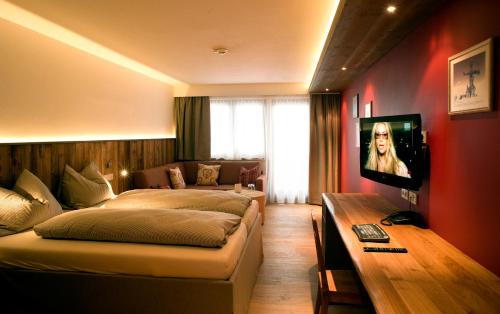 a hotel room with a bed and a television at Lifestyle Hotel eder in Maria Alm am Steinernen Meer