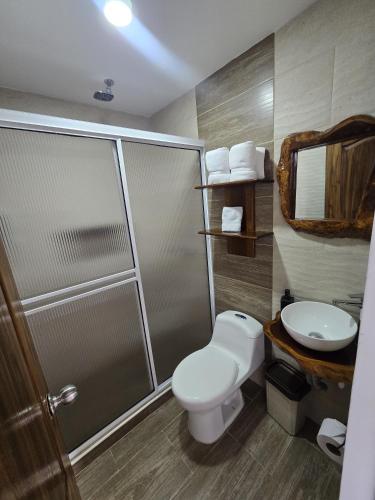 a bathroom with a shower and a toilet and a sink at Hospedaje Vista Hermosa Salento in Salento